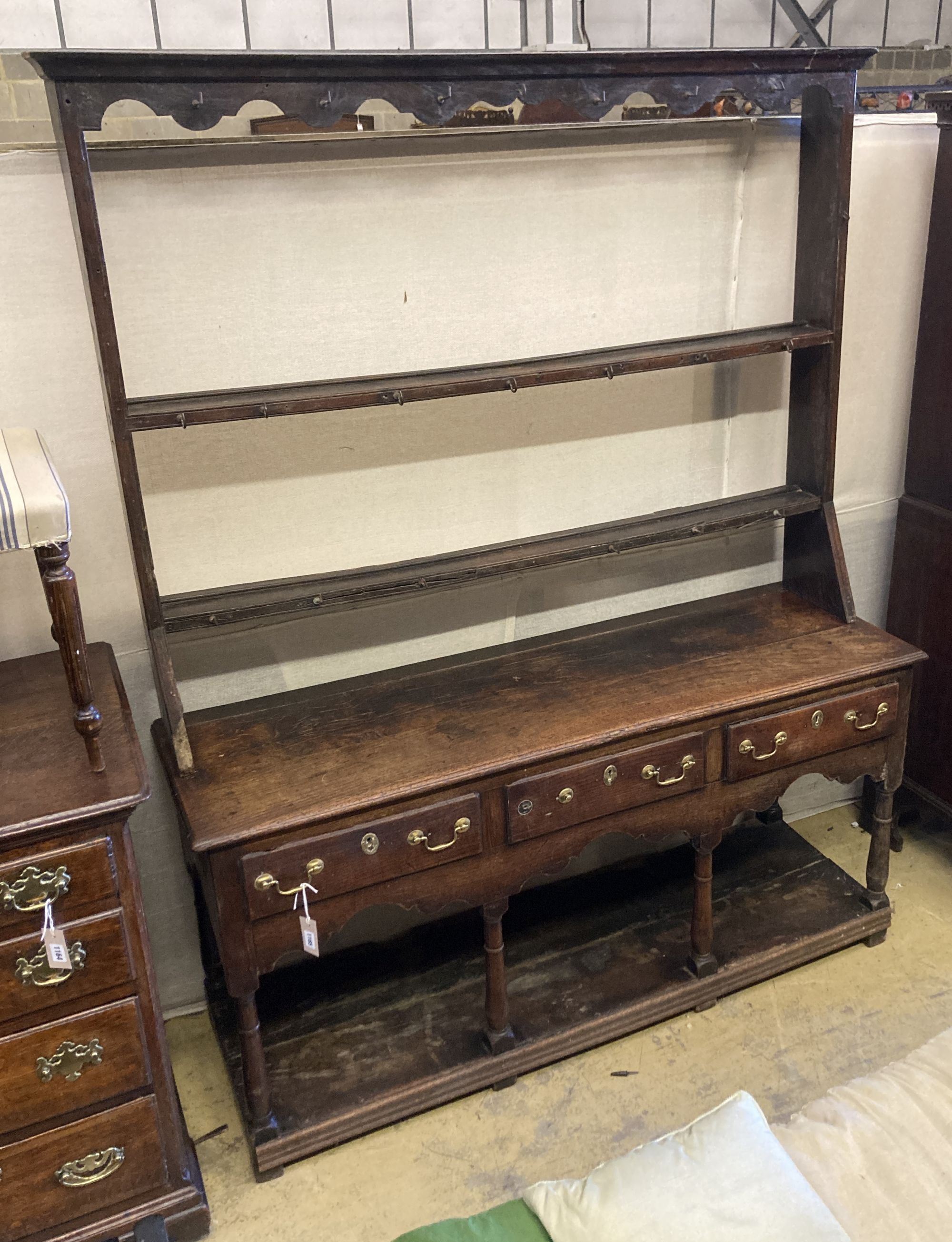 An 18th century oak potboard low dresser with associated rack, length 152cm, depth 48cm, height 193cm